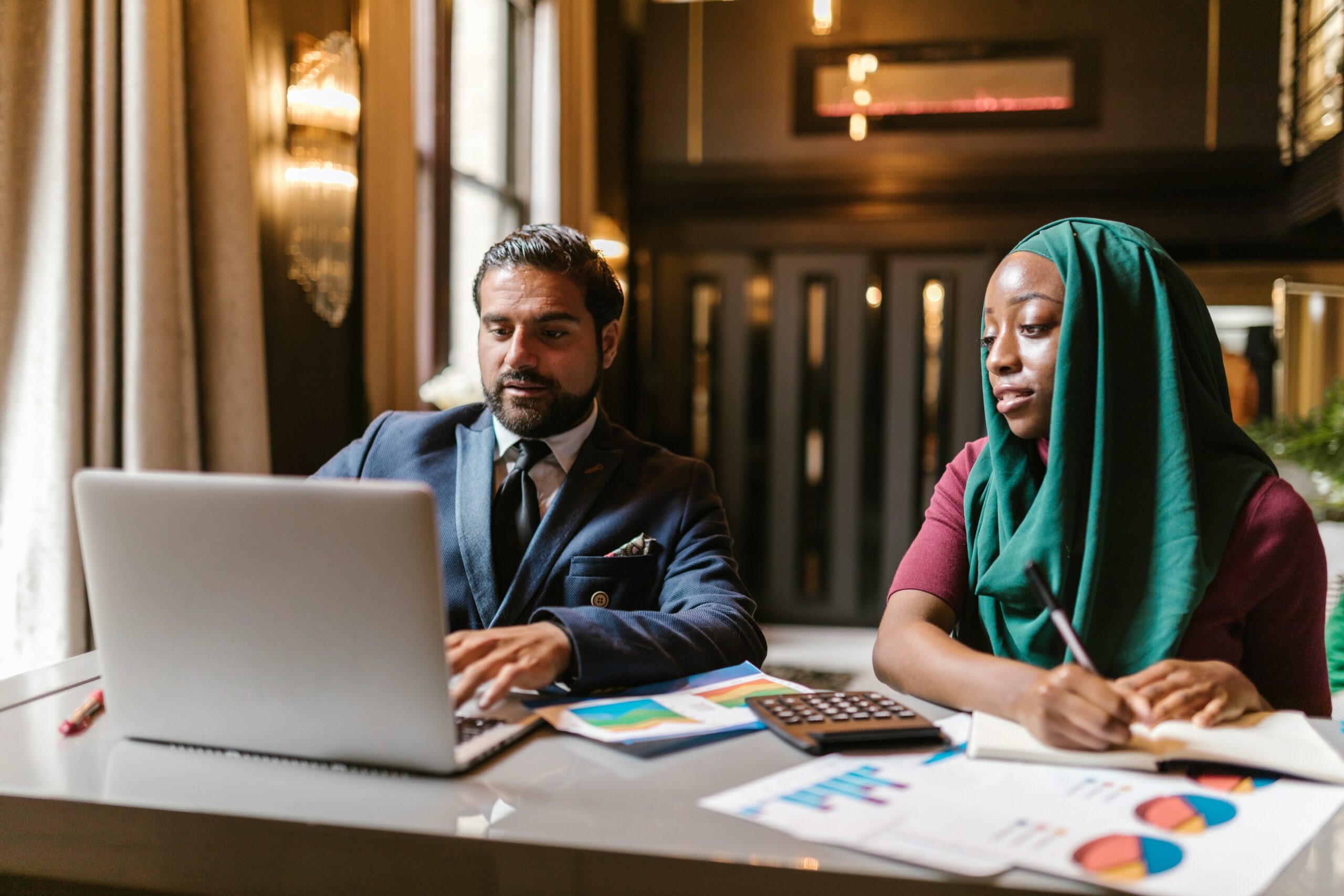 Two people working side by side in front of a laptop. Customized L&D Program